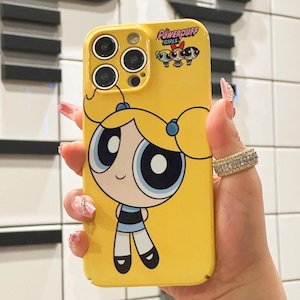 Könnte beinhalten: Gelbe Handyhülle mit einem Cartoon-Charakter aus der Serie Powerpuff Girls. Die Hülle zeigt ein Bild von Blümchen mit ihren blonden Haaren und blauen Augen. Das Powerpuff Girls-Logo befindet sich oben rechts.