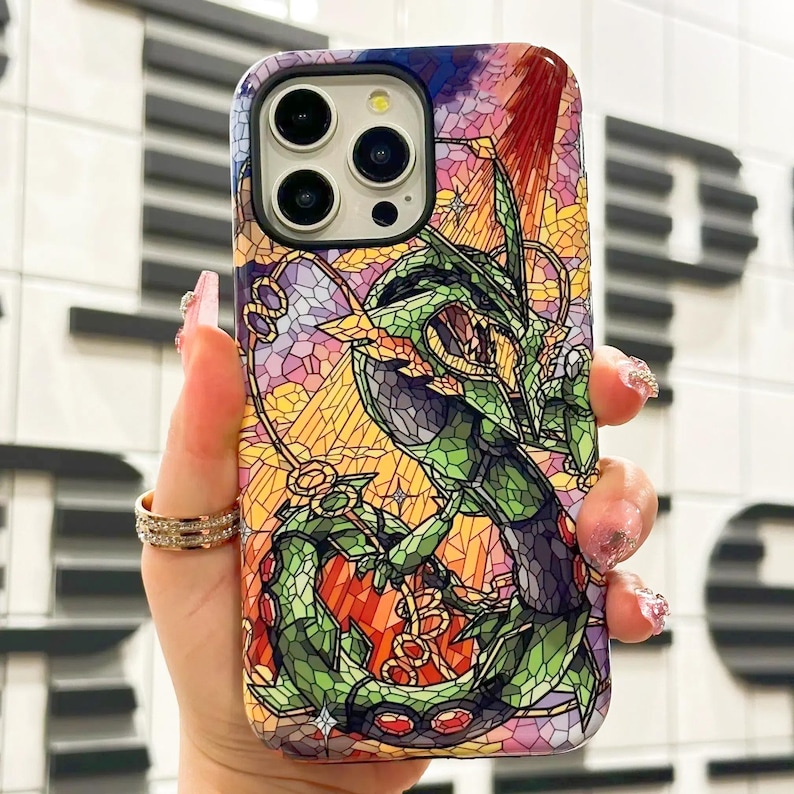 May include: A stained glass style phone case featuring a green dragon with red and purple accents. The case is designed for an iPhone.