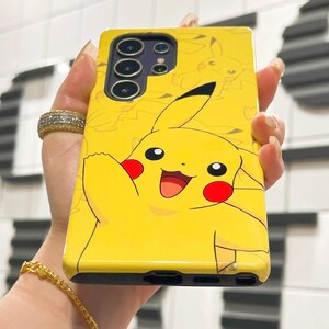 May include: A yellow phone case with a cartoon Pikachu design. The case has a black camera bump with three lenses.