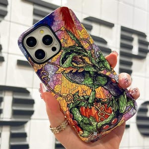 May include: A colorful phone case with a stained glass design featuring a green dragon. The case is designed for an iPhone with a camera lens cutout.