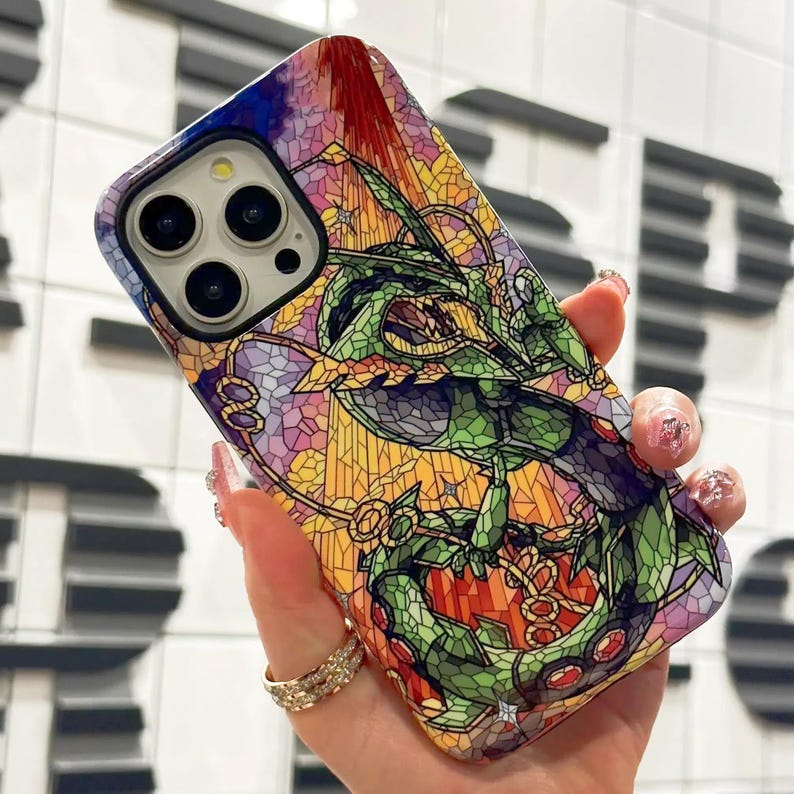 May include: A colorful phone case with a stained glass design featuring a green dragon. The case is designed for an iPhone with a camera lens cutout.