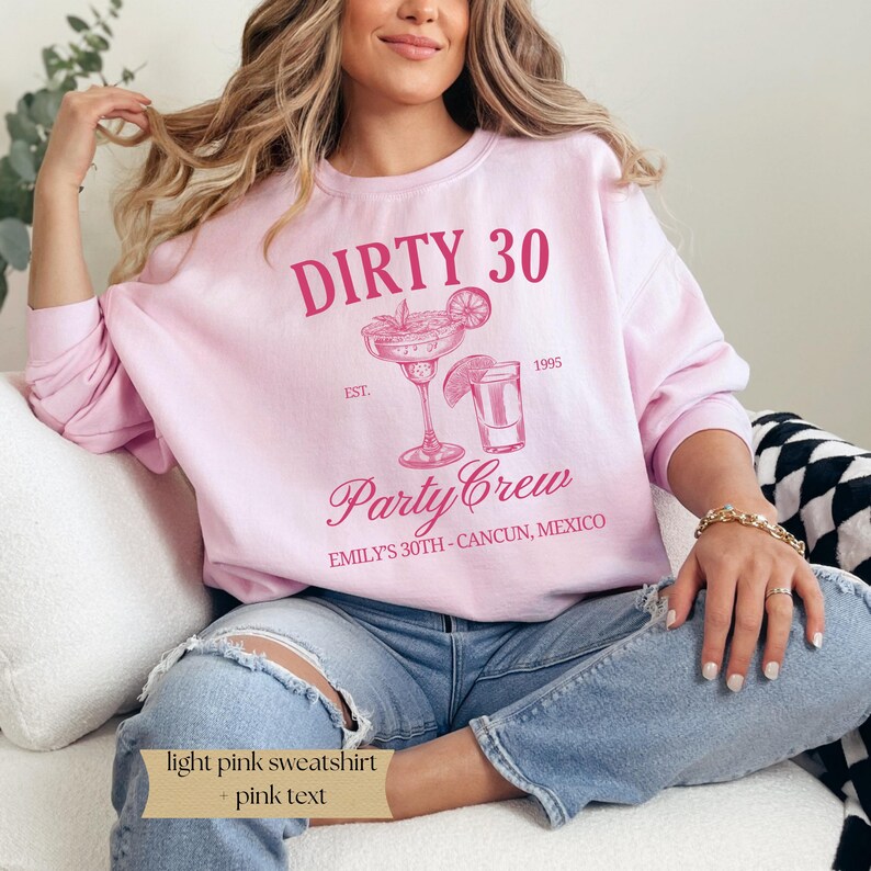 May include: Light pink sweatshirt with the text "DIRTY 30 EST. 1995 Party Crew EMILY'S 30TH - CANCUN, MEXICO" in pink. The sweatshirt features a graphic of a margarita and a shot glass.