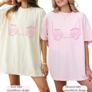 May include: Two oversized t-shirts with a seashell design. The ivory shirt says "Olivia's Bachelorette Punta Cana June 2023". The pink shirt says "Olivia's Bachelorette Punta Cana June 2023".