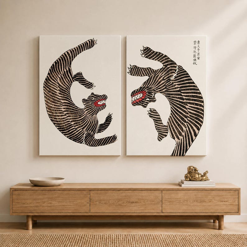 May include: Two rectangular wall art canvases featuring stylized black and white striped tigers in dynamic poses. Each tiger has a visible red mouth with sharp teeth. The right canvas includes vertical black Asian characters in the upper corner.