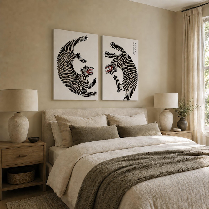 May include: Two rectangular wall art prints featuring stylized black and white tigers with red accents on their mouths. The tigers are depicted in dynamic, curved poses against a plain white background, displayed side by side above a bed.
