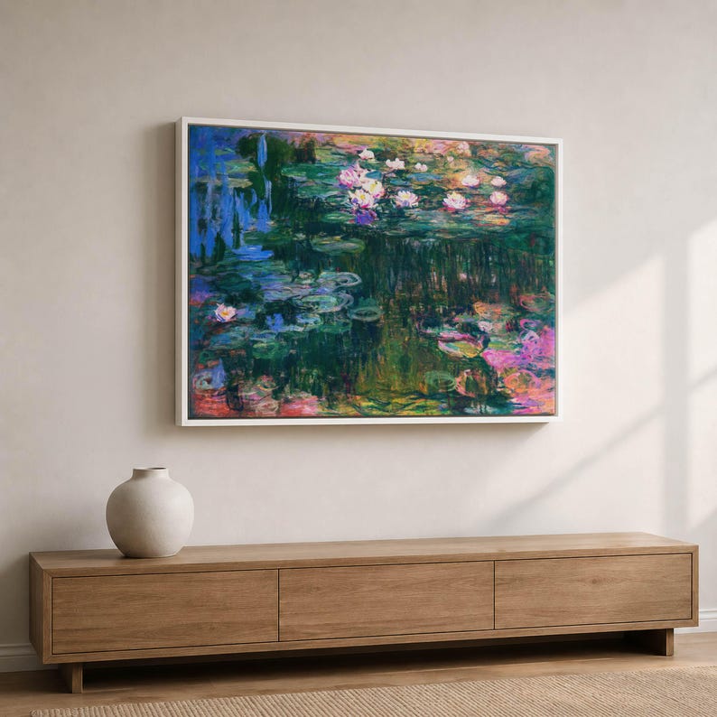 May include: A rectangular framed wall art print featuring an impressionist painting of a pond with water lilies. The artwork displays deep green, blue, and purple tones with highlights of pink and white flowers floating on the water surface.