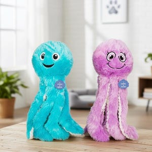 May include: Two plush octopus toys, one turquoise and one lavender, with smiling faces and long tentacles. Each toy has a small tag. The toys are on a wooden surface.