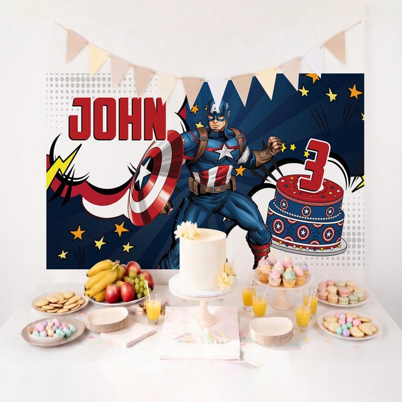 May include: A birthday party scene with a Captain America theme. A backdrop features Captain America and the name "JOHN". A white cake, cupcakes, cookies, and fruit are on the table. A cake with a number 3 is also present. A banner of pennants hangs above.