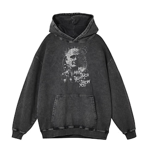 May include: A black hooded sweatshirt with a distressed look. The front of the sweatshirt features a graphic of a character from the horror film "Hellraiser" with the text "We have such sights to show you".