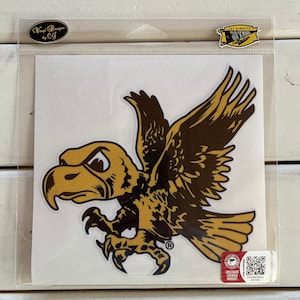 May include: A vinyl sticker featuring a stylized gold and brown eagle with outstretched wings. The sticker is in a clear plastic sleeve with the text "Vinyl Designs by CJ" and "Iowa Hawkeyes Old School" on the packaging.