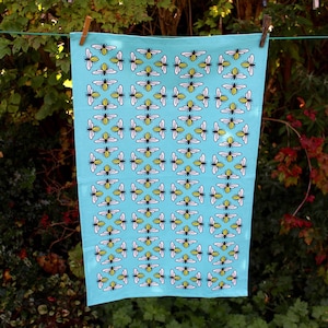 Peut inclure: Un torchon de cuisine bleu avec un motif répétitif d'abeilles jaunes et noires. Les abeilles sont stylisées et ont un design simple.