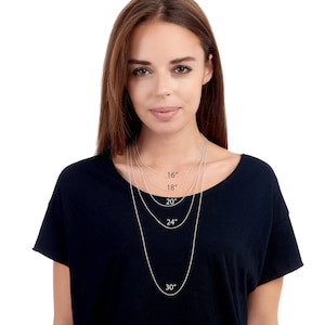 May include: A model is wearing a black top with five silver chains of different lengths. The chains are labelled with their lengths in inches: 16", 18", 20", 24", and 30".