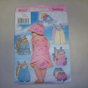 May include: A sewing pattern for baby clothes, featuring a pink dress with a yellow trim, a blue and white striped dress, a red and white gingham dress, and a blue and white gingham sun hat. The pattern number is B5625 and the size is Large (Lrg-Xlg).