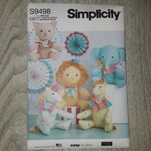 May include: Simplicity sewing pattern S9498 for making five plush toys: a cat, an elephant, a lion, a horse, and a giraffe. The pattern includes instructions for making the toys and a variety of accessories, such as bows, crowns, and party hats.
