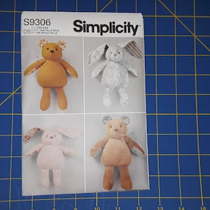 May include: A Simplicity sewing pattern for making plush toys. The pattern includes instructions for making a brown bear, a pink bunny, and a white bunny. The pattern number is S9306. The pattern is for one size.
