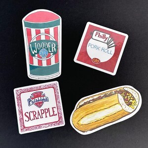 May include: Four stickers featuring regional food themes: a red and white striped cup labeled Wooder Ice, a square Philly Pork Roll label, a square Philadelphia Scrapple label with a red border, and a detailed illustration of a cheesesteak sandwich.