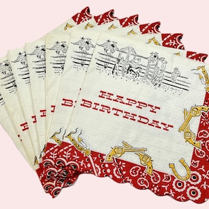May include: A stack of vintage white handkerchiefs with a red scalloped border. Each handkerchief features a cowboy-themed design with the words "HAPPY BIRTHDAY" in red. The design includes cowboys, horses, guns, and a horseshoe.