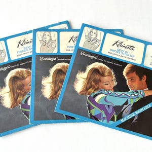 Puede incluir: Varios paquetes de protectores de axilas para coser Kleinert's para mangas largas. El embalaje azul y blanco presenta un diseño retro con una pareja. El texto incluye "Sanitized" y "Machine Washable".