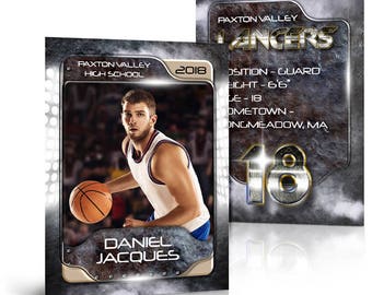 May include: A basketball trading card featuring a player in a white jersey with blue trim, dribbling a basketball. The card has a silver and black background with the text "Paxton Valley High School" and "Daniel Jacques".