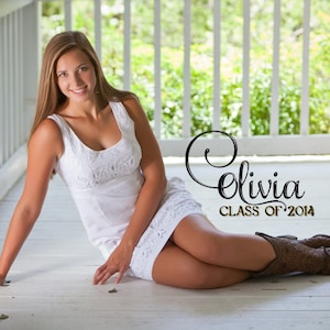May include: A young woman in a white dress sits on a wooden porch with a white railing. She is smiling and looking at the camera. The text "Olivia Class of 2014" is written in black and gold lettering on the porch.