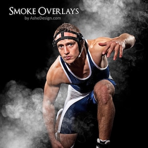 May include: A wrestler in a blue and white singlet with a black headgear is in a fighting stance with smoke behind him. The text "SMOKE OVERLAYS by AsheDesign.com" is at the top of the image.