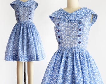 Vestido azul vintage de los años 60, corte entallado y acampanado con cuello chal, talla pequeña.
