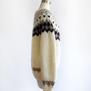 side view of a vintage 1970s Fair Isle zip up sweater on a mannequin against a white background