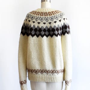 back view of a vintage 1970s Fair Isle zip up sweater on a mannequin against a white background