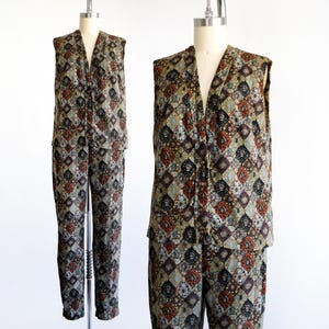 May include: A vintage two-piece outfit featuring a sleeveless vest and matching pants. The ensemble is patterned with a repeating geometric design in shades of brown, green, and rust. The vest has a V-neck and the pants are straight-legged.