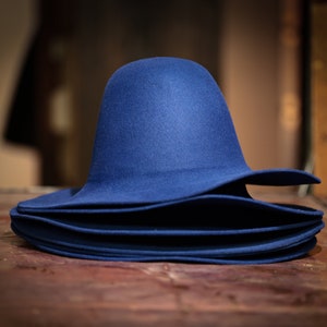 May include: A stack of blue felt hats, each with a wide brim and a rounded crown.