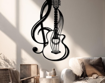 Op de afbeelding: Zwarte metalen wandkunst met een gitaar en een G-sleutel. De gitaar is gedetailleerd met snaren en een klankgat. Het kunstwerk is op een neutrale muur gemonteerd, wat een opvallend contrast creëert. Ideaal voor muziekliefhebbers.