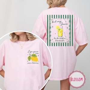May include: Pink t-shirt with a lemon graphic and the text "Life gave me some lemons" on the front. The back features a lemonade graphic and the text "but my Jesus he be makin' lemonade".