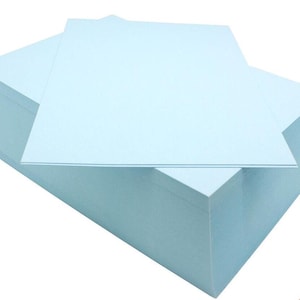 May include: A stack of light blue index cards. The cards are arranged in a rectangular shape and are ready for note-taking or crafting.