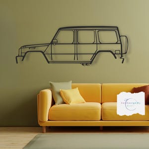 May include: A black metal outline of a car, mounted on a green wall above a yellow couch with green and yellow throw pillows. The text "ZedDesignByCraft" is visible on the couch.