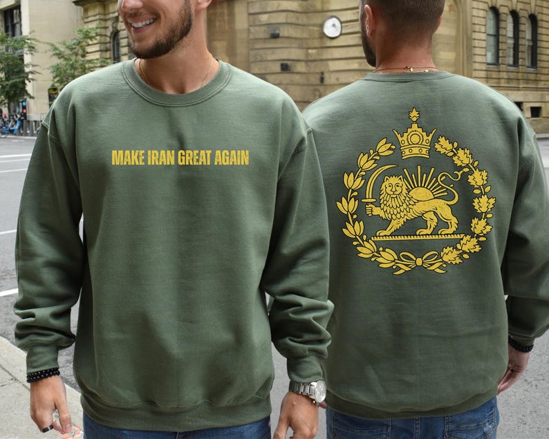 May include: Olive green sweatshirt with the text "MAKE IRAN GREAT AGAIN" in gold lettering on the front. The back features a gold emblem with a lion, crown, and sun design. The sweatshirt is a crew neck style.