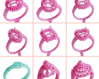 May include: Nine pink and one turquoise plastic ring molds for jewelry making. The molds are designed to hold different shaped gemstones.