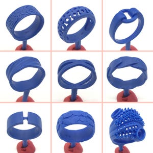 Peut inclure: Neuf bagues en cire bleue avec différents motifs et textures. Les bagues sont présentées sur de petits supports rouges.