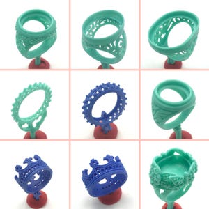 May include: Nine different wax ring molds for jewelry making. The molds are in various shapes and sizes, including rings, crowns, and bands. The molds are made of a light green and blue plastic material.