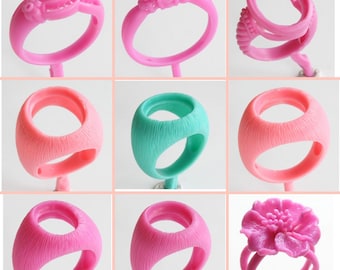May include: Nine pink and one turquoise wax ring molds for jewelry making. The molds are in various styles, including a simple band, a ring with a flower design, and a ring with a setting for a stone.