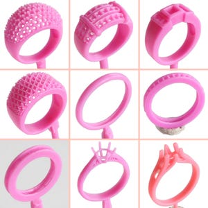 Peut inclure: Neuf modèles de bagues en cire rose pour la fabrication de bijoux. Les bagues sont présentées sur un fond blanc.