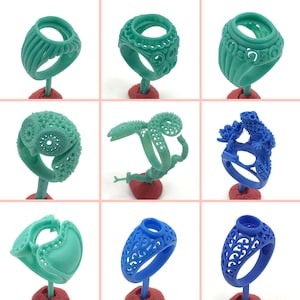 May include: A collection of nine turquoise and blue rings with intricate designs. The rings are displayed on small stands.