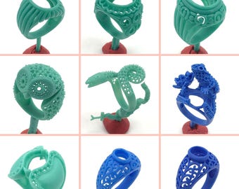 May include: A collection of nine turquoise and blue rings with intricate designs. The rings are displayed on small stands.