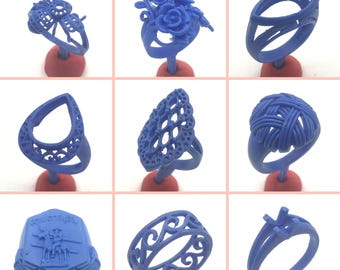 May include: Nine different blue wax ring designs for jewelry making. The rings are displayed on small red stands.