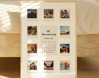 May include: A white framed photo collage with a calendar for October 2023. The calendar is titled "1st Anniversary". The collage features 10 photos of a couple in various settings.