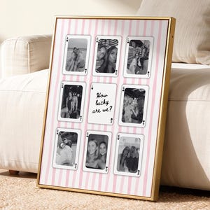May include: A rectangular framed wall art piece featuring a light pink and white vertical striped background. The design displays nine playing card-style rectangles, eight containing black and white photographs and one central card with the text How lucky are we?