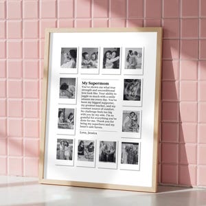 May include: A framed print with a light wood frame, featuring a collection of black and white photos. The print includes the text "My Supermom" and a heartfelt message, along with the name "Jessica". The background is a pink tiled wall.