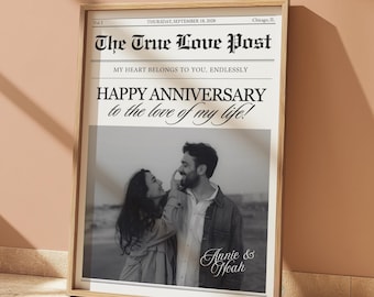 May include: A framed print resembling a newspaper front page. The headline reads "The True Love Post" with the date "Thursday, September 18, 2028." Below, a black and white photo of a couple is featured, with the text "HAPPY ANNIVERSARY to the love of my life!" and the names "Annie & Noah."