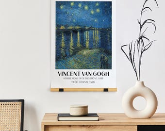 May include: A framed art print of Vincent van Gogh's "Starry Night Over the Rhone" from 1888, displayed on a wooden hanger. The artwork depicts a night scene with a river reflecting city lights and a starry sky. The text "Vincent Van Gogh" is at the bottom.
