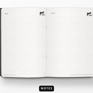 May include: Open notebook with lined pages, featuring a black cover and a white interior. The word "NOTES" is printed at the top of each page and at the bottom. Small cow illustrations are at the top of each page.