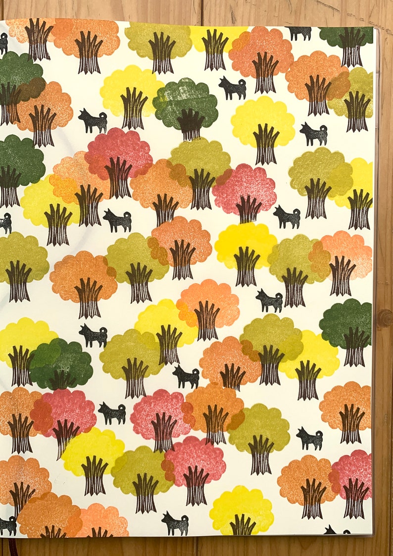 Pode incluir: Um fundo branco com um padr&atilde;o repetitivo de &aacute;rvores e c&atilde;es. As &aacute;rvores est&atilde;o em v&aacute;rios tons de verde, amarelo, laranja e vermelho. Os c&atilde;es s&atilde;o pretos e todos est&atilde;o virados para a mesma dire&ccedil;&atilde;o.